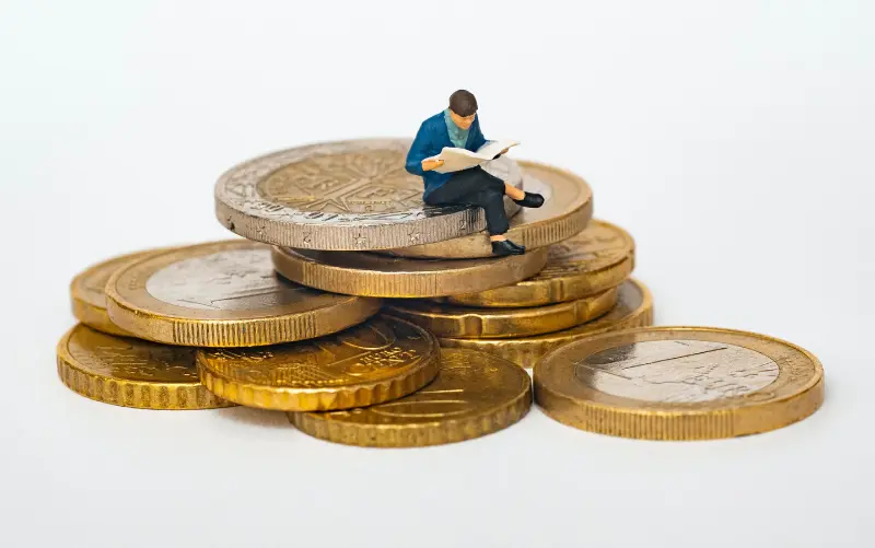 Eine kleine Figur sitzt auf Geldstücken und informiert darüber, wie er seine Liveblogs einfach und lukrativ monetarisiert kann.