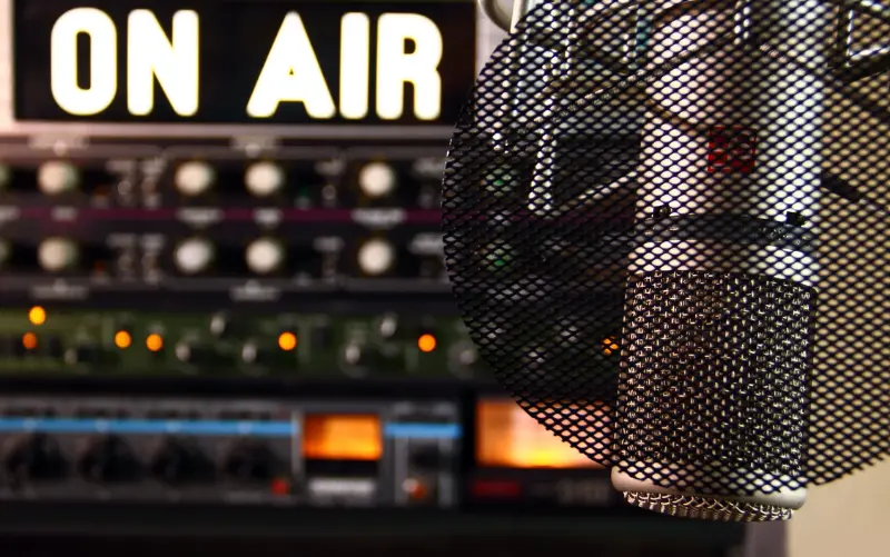 A radio show setup: On Air sign is on behind a microphone 