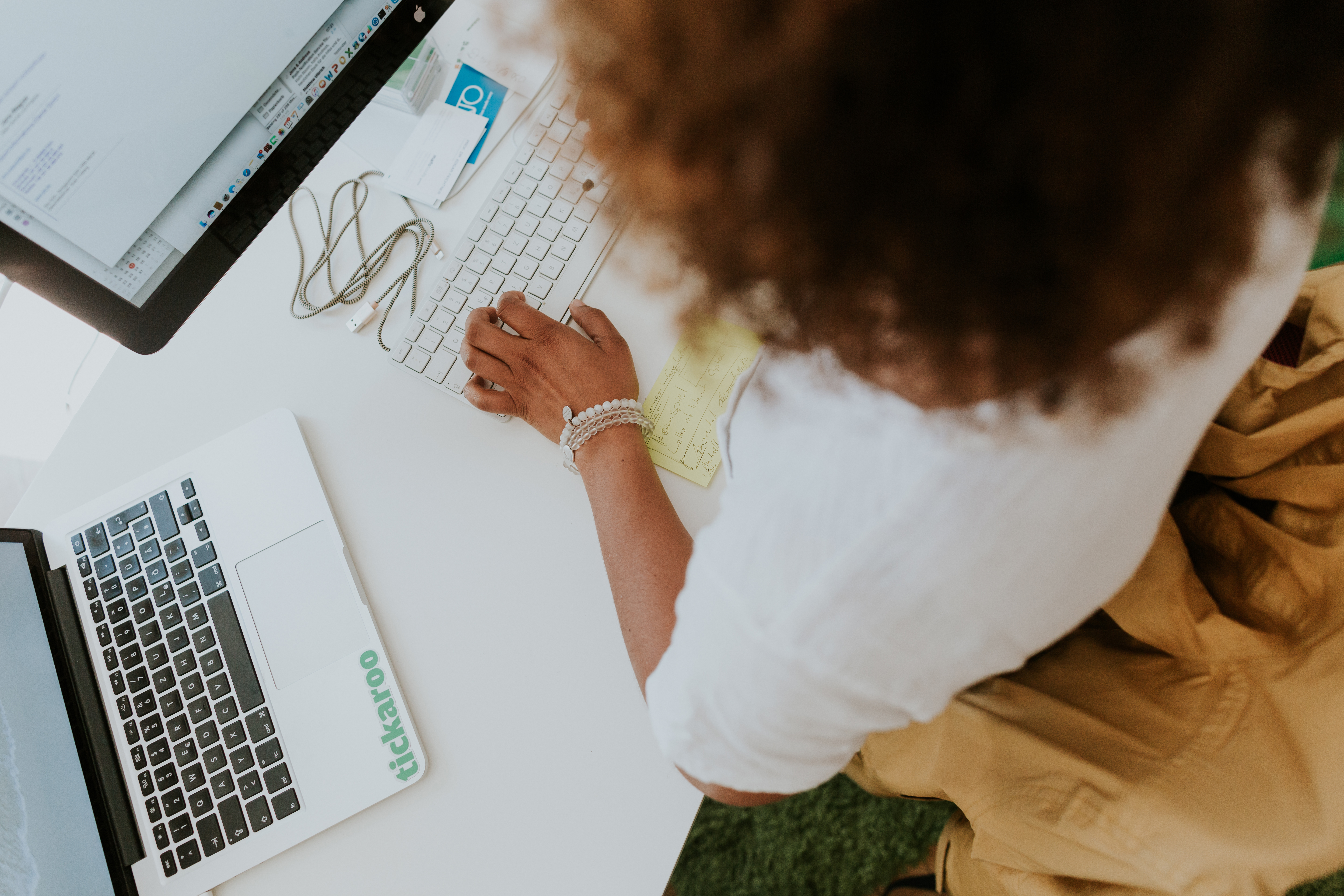 Naomi Owusu, CEO of Tickaroo stands at her desk, working intently and preparing for the workday.